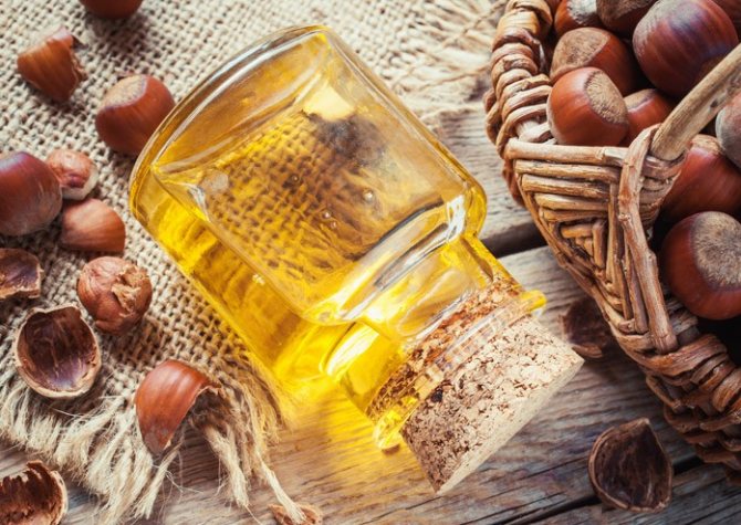 Бутылка с маслом фундука и орехи в корзине